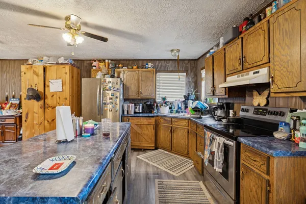 a kitchen with stainless steel appliances granite countertop a sink a stove and refrigerator