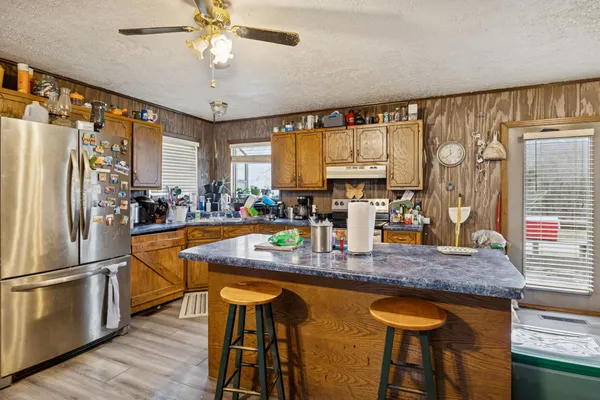 a kitchen with stainless steel appliances granite countertop a sink a stove and a refrigerator