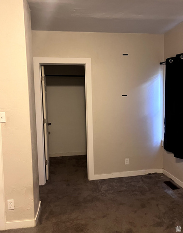 3161 Adams Avenue Ogden, UT 84403 - Photo 9 of 17 Interior room featuring a closet with an open door, neutral-toned walls, and dark carpet