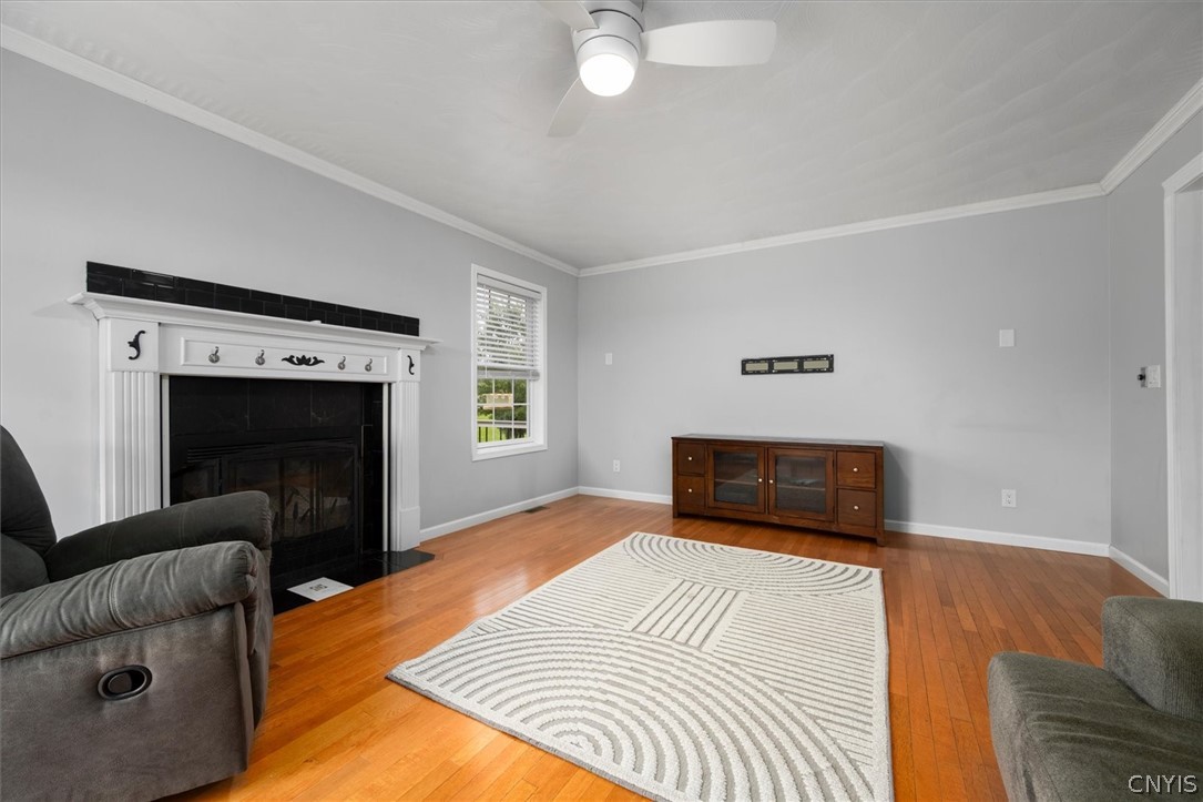 1322 Sawmill Road Sangerfield, NY 13480 - Photo 16 of 50 Rich hardwood floors and a classic wood-burning fireplace anchor this versatile living space.