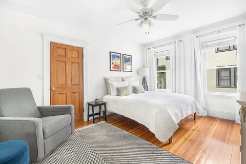 a bedroom with a large bed couch and a window