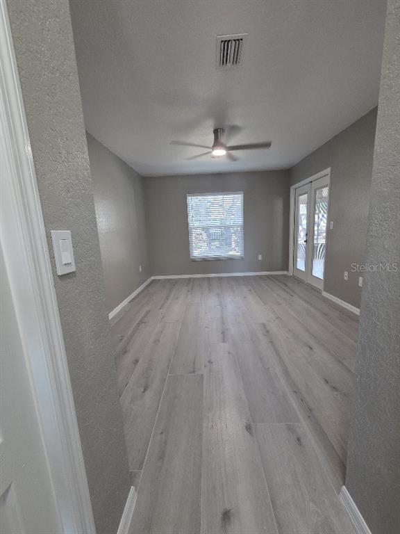 Undisclosed Address Spring Hill, FL 34609 - Photo 16 of 50 an empty room with wooden floor and windows