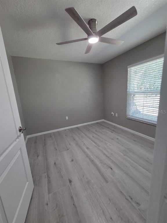 Undisclosed Address Spring Hill, FL 34609 - Photo 32 of 50 an empty room with wooden floor and windows