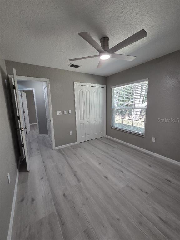 Undisclosed Address Spring Hill, FL 34609 - Photo 38 of 50 a view of an empty room with wooden floor and a window