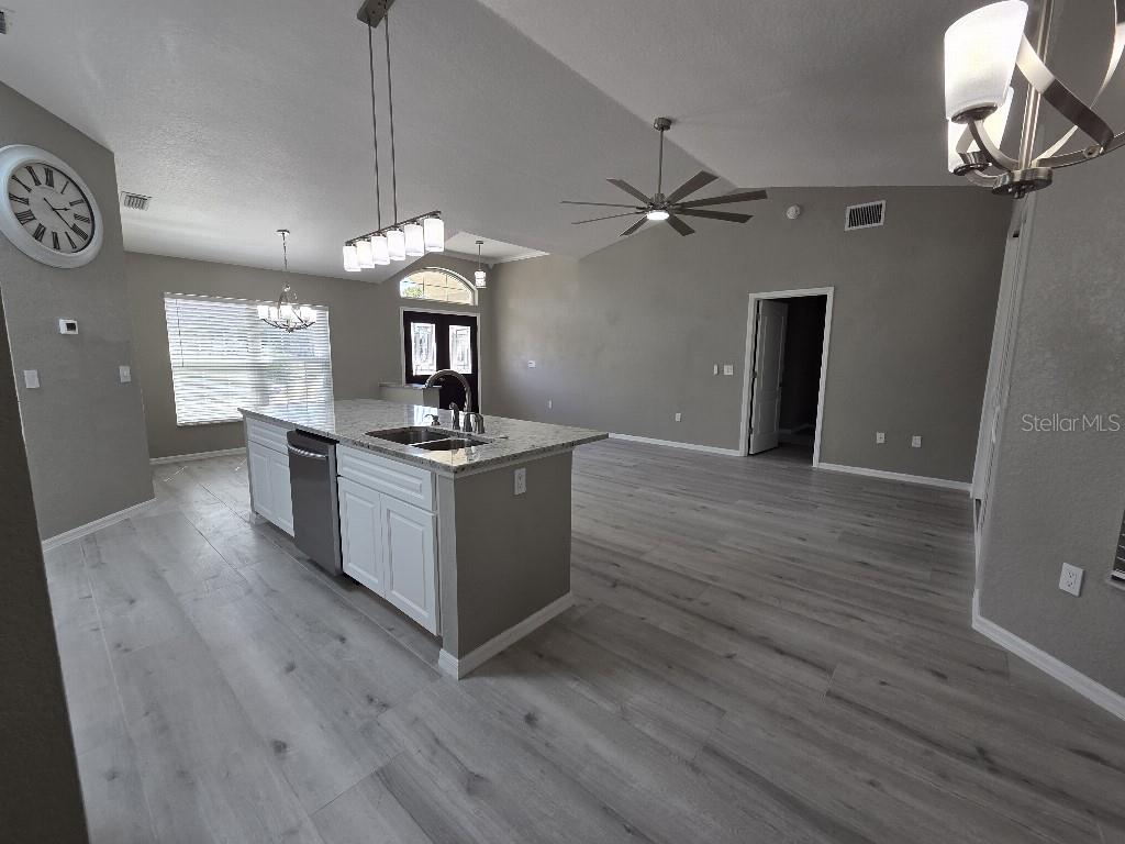 Undisclosed Address Spring Hill, FL 34609 - Photo 8 of 50 a kitchen with stainless steel appliances granite countertop a stove a sink and a wooden floor