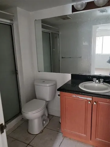 a bathroom with a sink a toilet a mirror and vanity