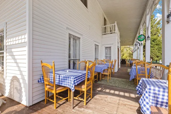 a room with lots of white furniture and a chandelier