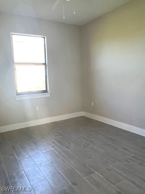 712 Dade Street, Unit 2 Immokalee, FL 34142 - Photo 5 of 5 an empty room with wooden floor and windows
