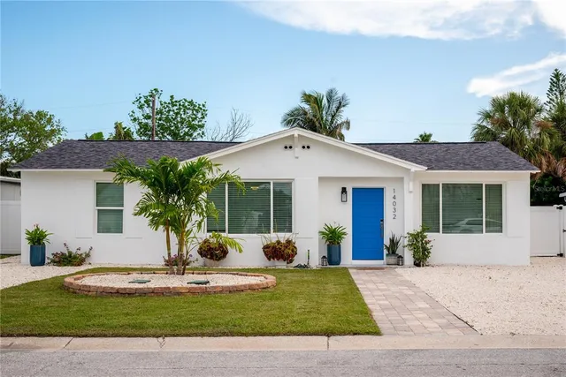 a view of a house with a yard and potted plants