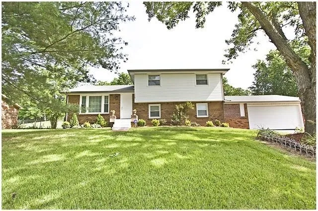 a front view of house with yard and trees