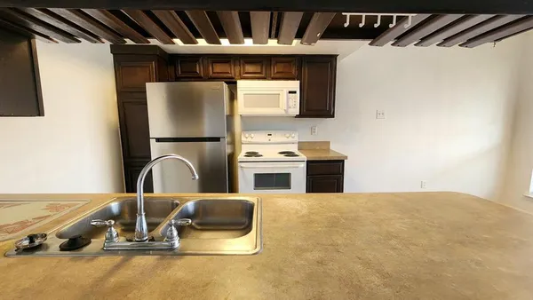 a kitchen with stainless steel appliances a stove top oven a sink and a microwave