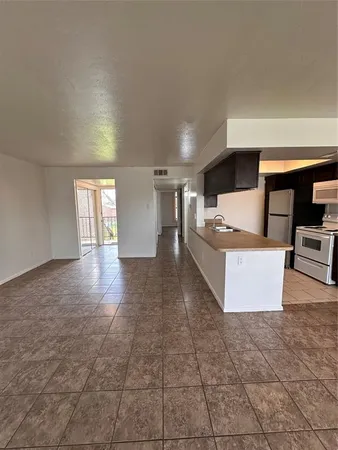 a large hall with stainless steel appliances granite countertop a barbecue grill and cabinets