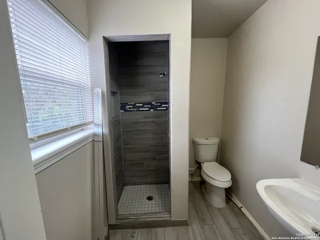 a bathroom with a toilet and a shower