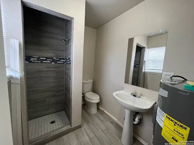 a bathroom with a sink toilet and shower