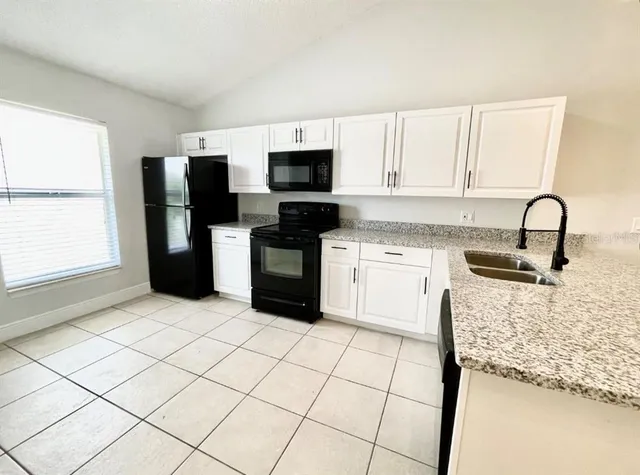 a kitchen with a refrigerator sink and cabinets