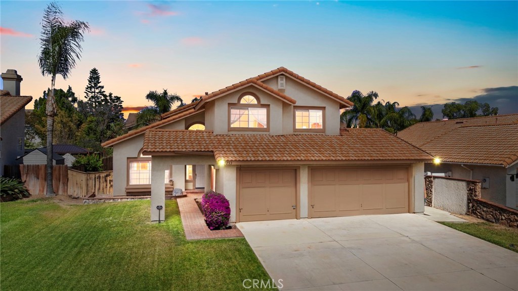 9253 Sunridge Drive Riverside, CA 92508 - Photo 1 of 57 a front view of a house with a yard and garage