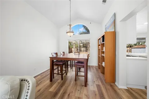 a dining room with wooden floor and a chandelier