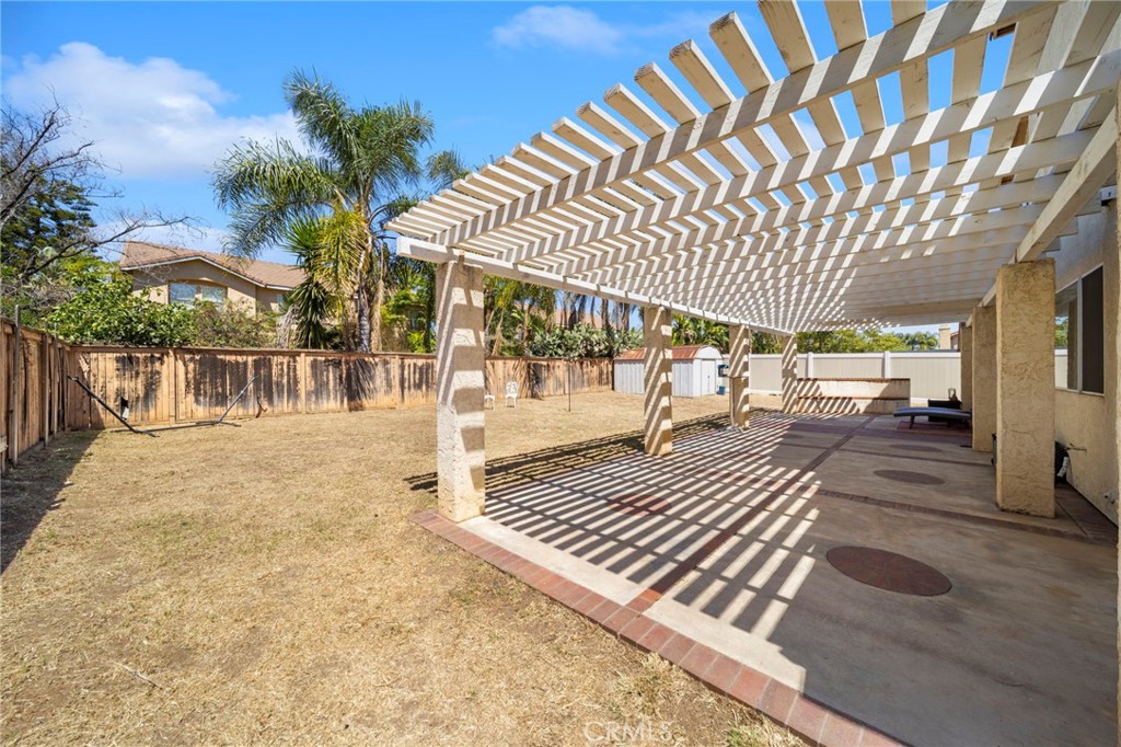 9253 Sunridge Drive Riverside, CA 92508 - Photo 44 of 57 a view of a patio with a table and chairs under an umbrella with wooden floor