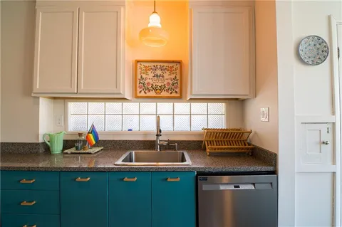 a kitchen with stainless steel appliances granite countertop a sink and a white cabinets