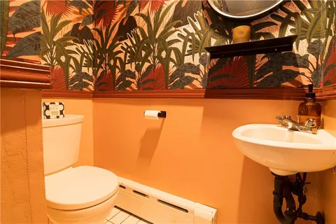 a bathroom with a toilet sink and mirror