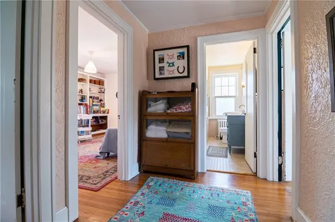 a view of a hallway with wooden floor and closet