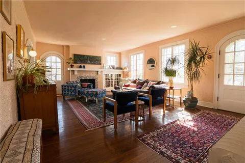 a living room with fireplace furniture and a rug