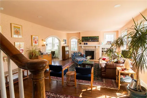 a living room with furniture a fireplace and potted plants