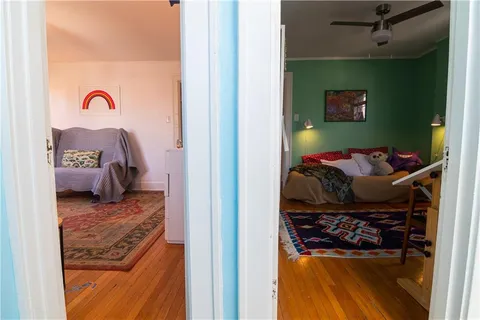 a view of a bedroom with a bed and a mirror
