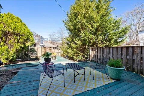a view of a chairs and table in patio with wooden fence