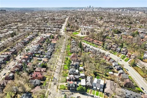 an aerial view of residential houses with city view