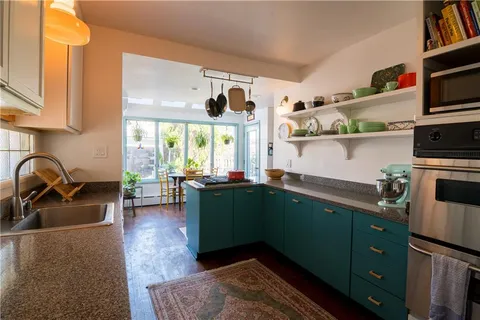 a kitchen with sink a window and cabinets