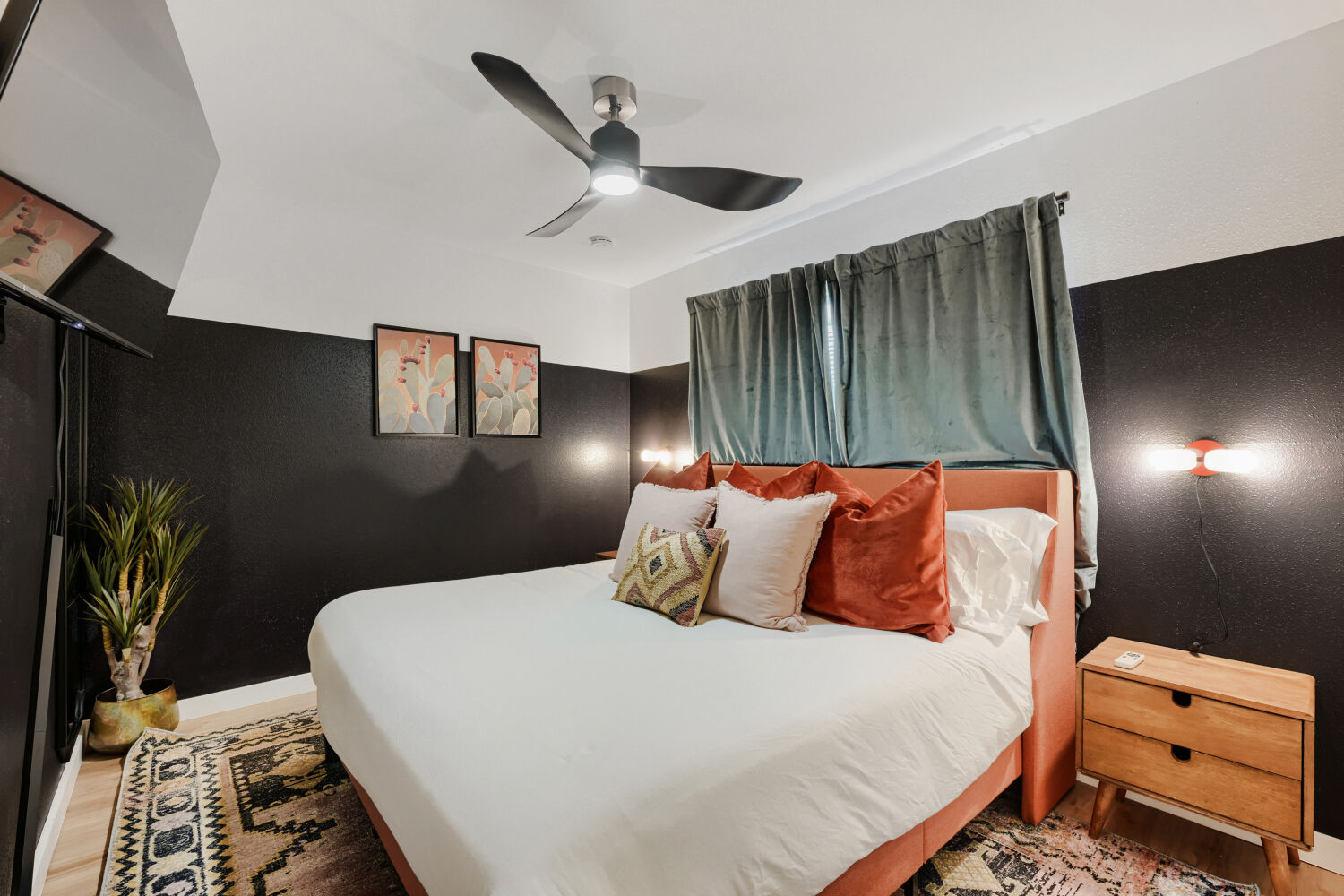 3410 Plantation Road Austin, TX 78745 - Photo 24 of 33 A comfortable bedroom features a modern ceiling fan, dark accent walls, and hardwood flooring.