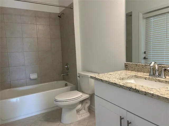 a bathroom with a granite countertop toilet a sink and bathtub