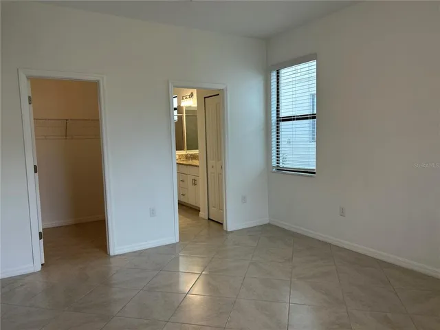 an empty room with windows and closet
