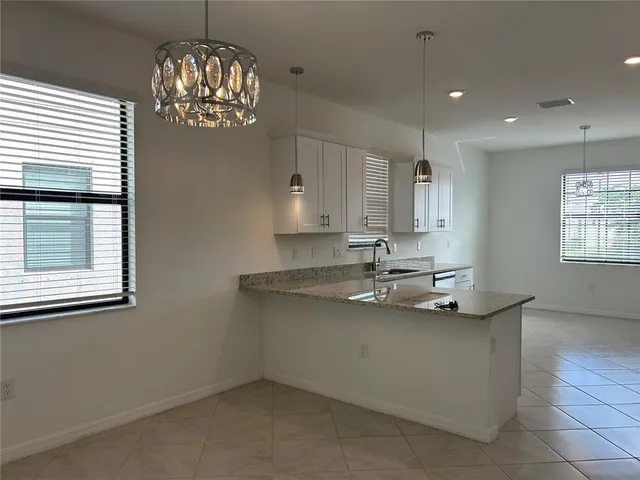 a kitchen with stainless steel appliances granite countertop a sink a stove and a window
