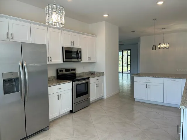 a kitchen with cabinets stainless steel appliances and wooden floor