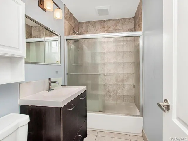 a bathroom with a sink mirror and a shower