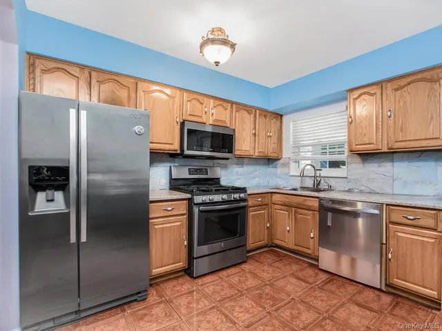 a kitchen with stainless steel appliances granite countertop a refrigerator stove top oven a sink and dishwasher