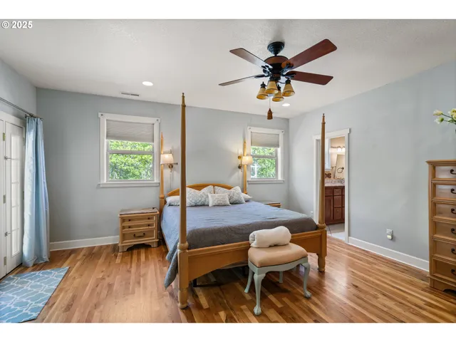 a living room with a dining table wooden floor and a ceiling fan