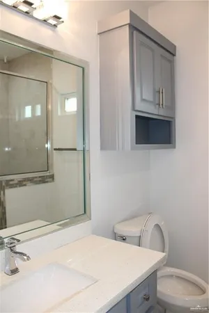 a bathroom with a toilet sink and mirror