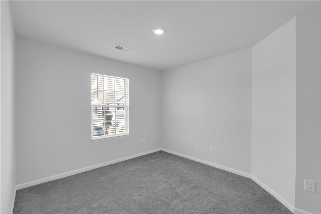 515 Brasstown Court Pendleton, SC 29670 - Photo 15 of 25 This cozy second bedroom features plush carpeting and a bright window, creating an inviting atmosphere for rest and relaxation.