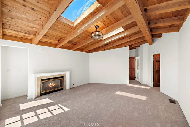 a view of an empty room with a fireplace and a window