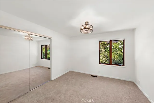 an empty room with windows and closet