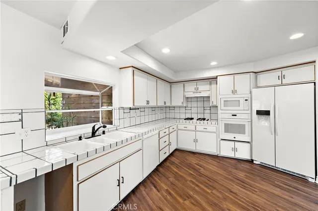 a kitchen with white cabinets and white appliances