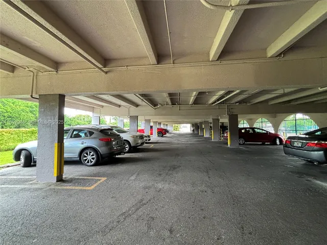 a view of parking garage with cars parked