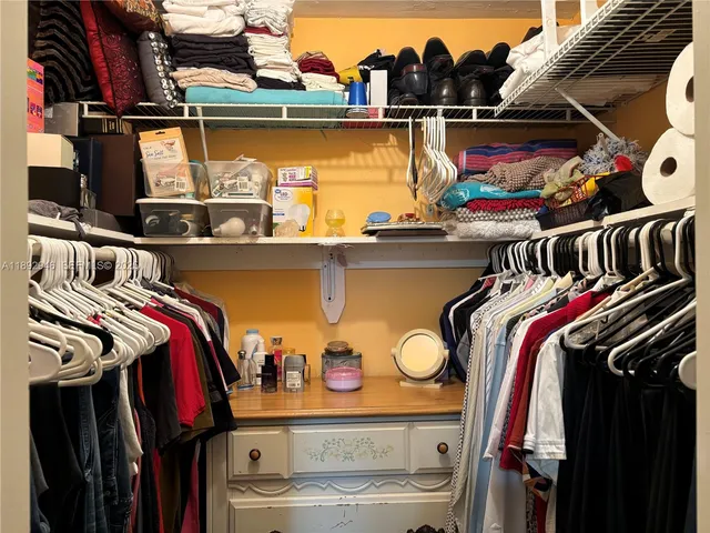 a view of walk in closet with clothes and shoes