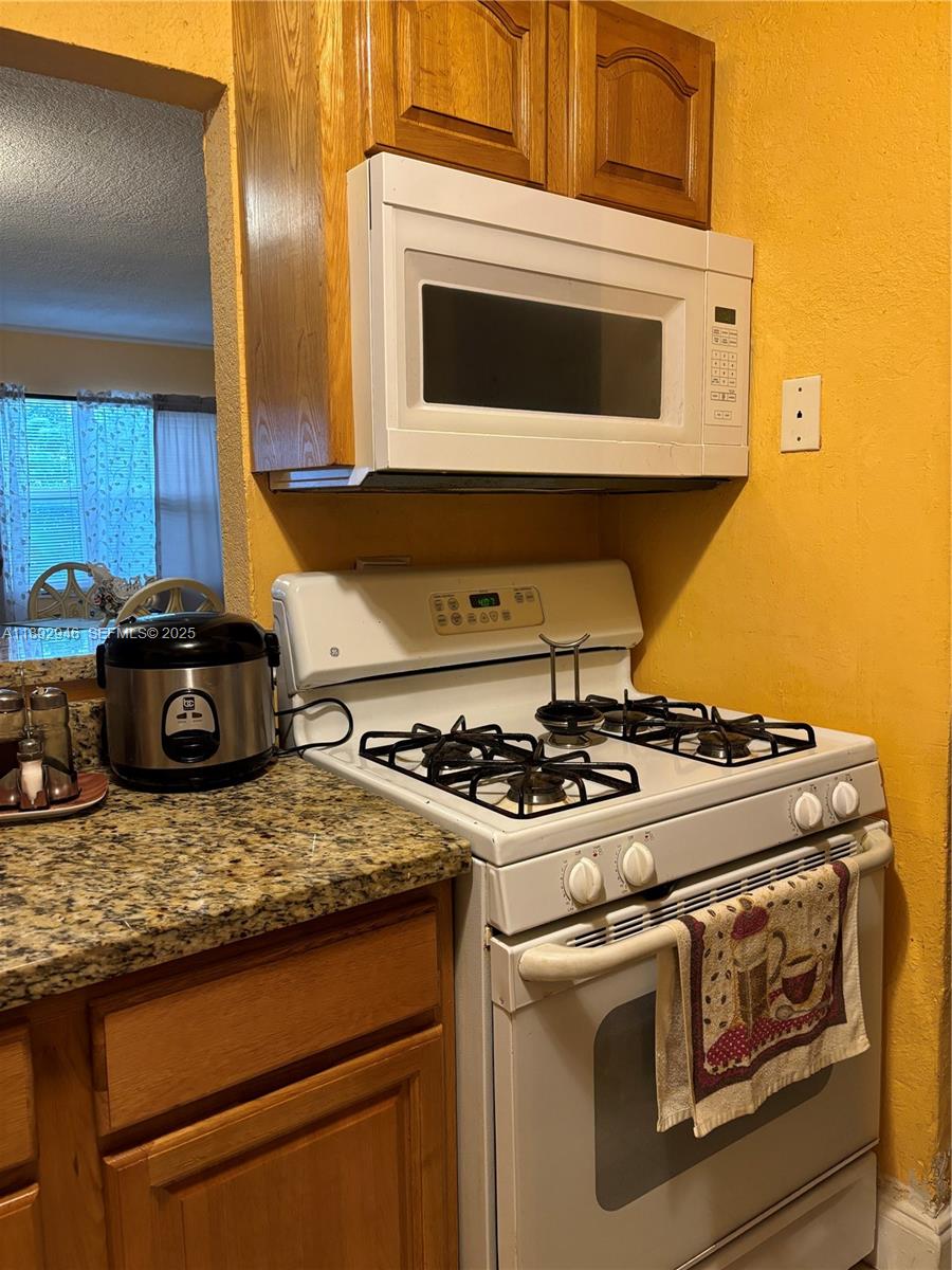 1350 West 53rd Street, Unit 24 Hialeah, FL 33012 - Photo 25 of 32 a stove top oven sitting inside of a kitchen