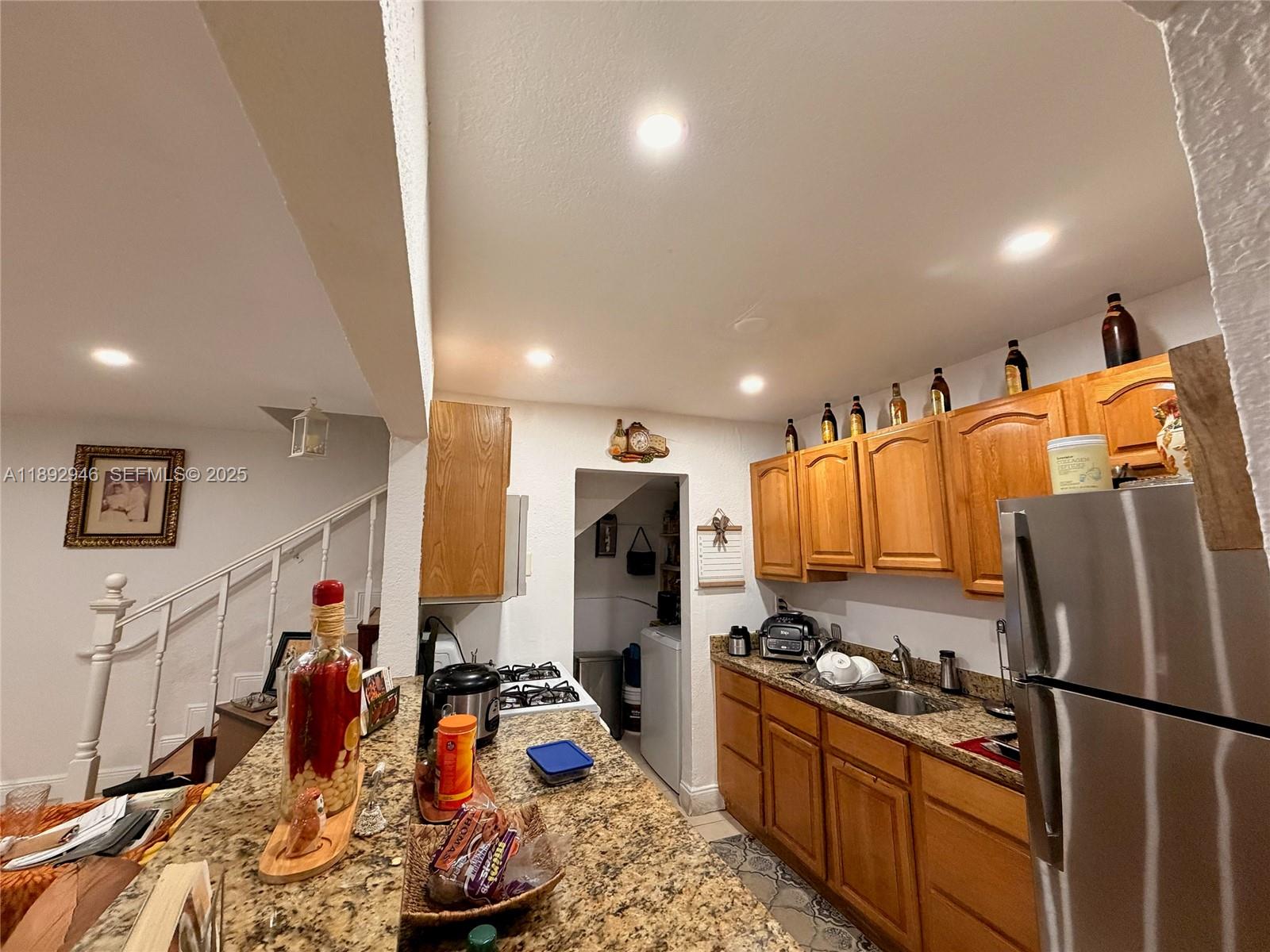 1350 West 53rd Street, Unit 24 Hialeah, FL 33012 - Photo 3 of 32 a kitchen with stainless steel appliances granite countertop a refrigerator sink and stove