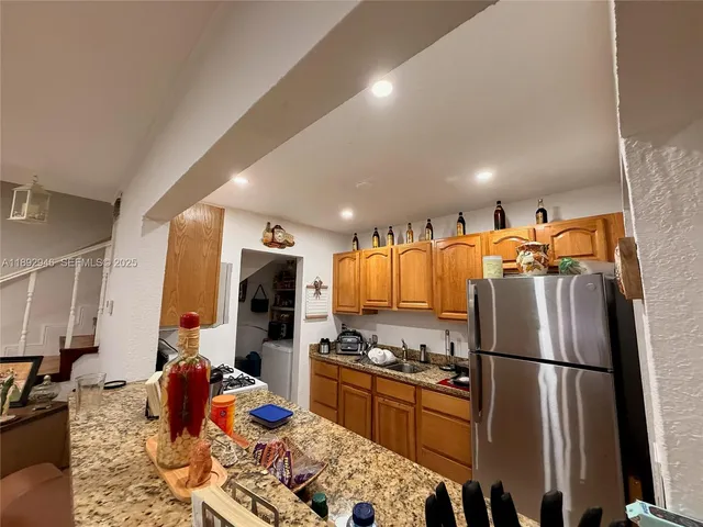 a kitchen with stainless steel appliances granite countertop a refrigerator sink and stove