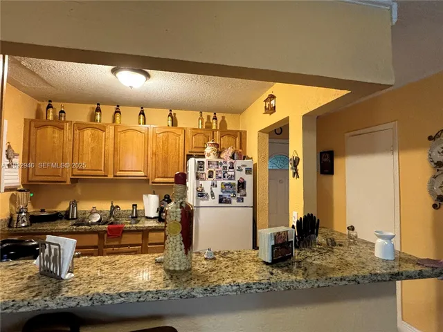 a kitchen with kitchen island granite countertop a sink and a counter top space